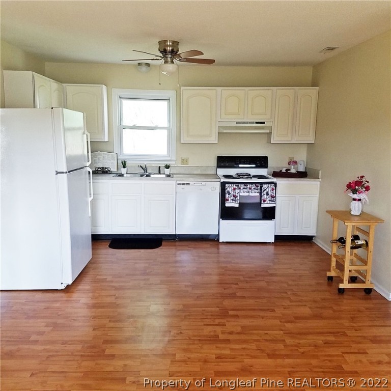 6596 Fisher Road Fayetteville, NC 28304 - Photo 5 of 27 a kitchen with a refrigerator and a stove top oven