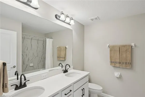 a bathroom with a sink a toilet and mirror