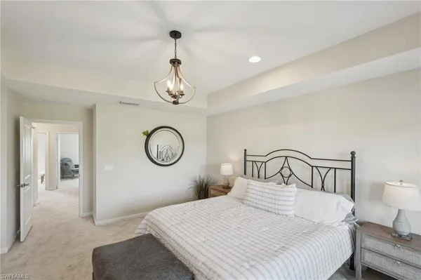 a bedroom with a large bed and a chandelier