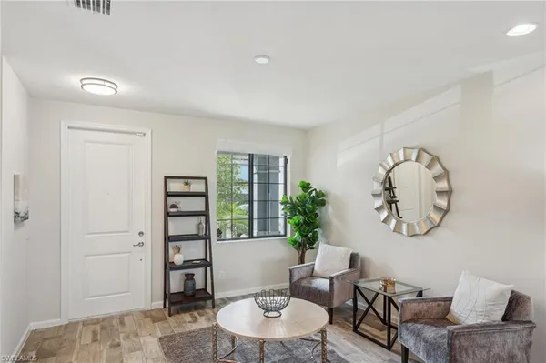 a living room with furniture a rug and a window