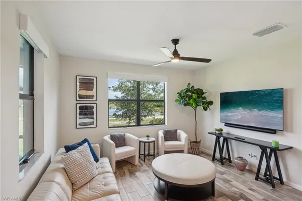 a living room with furniture a flat screen tv and a large window