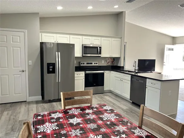 a kitchen with stainless steel appliances granite countertop a refrigerator sink and stove