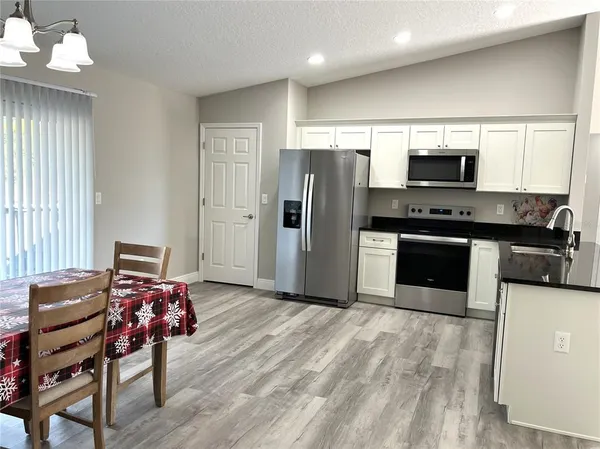 a kitchen with stainless steel appliances kitchen island granite countertop a refrigerator and a stove top oven