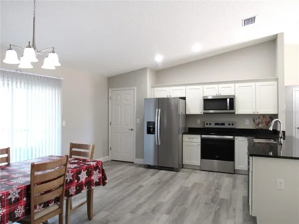 a kitchen with stainless steel appliances granite countertop a refrigerator and a stove top oven