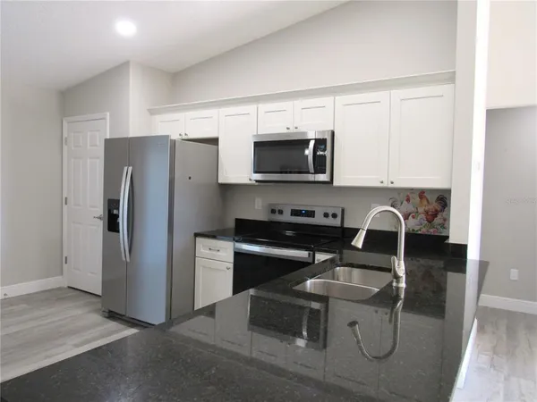 a kitchen with a refrigerator stove and microwave