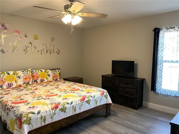 a bedroom with a bed and wooden floor