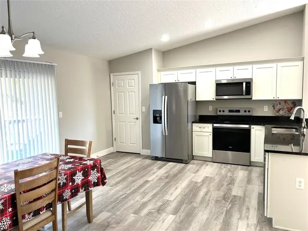 a kitchen with stainless steel appliances granite countertop a refrigerator and a stove top oven