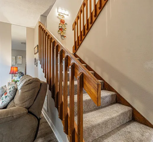 a living room with furniture and stairs