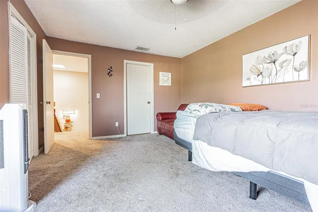 a bedroom with a bed and a painting on the wall