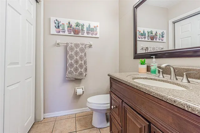 a bathroom with a granite countertop toilet sink and mirror