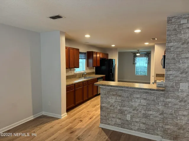 a kitchen with stainless steel appliances granite countertop a refrigerator and a sink