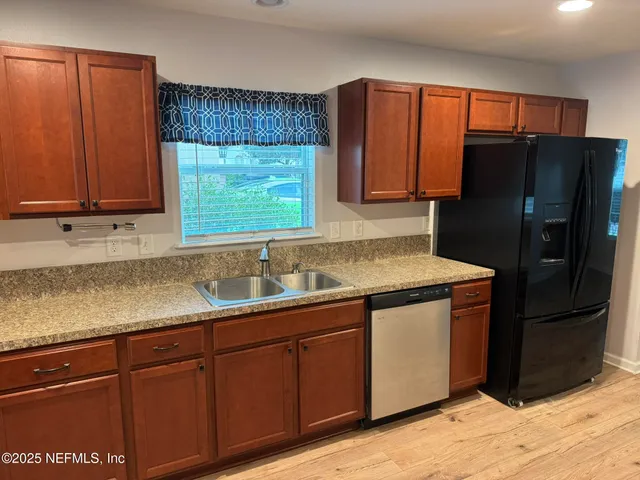a kitchen with sink a microwave and cabinets