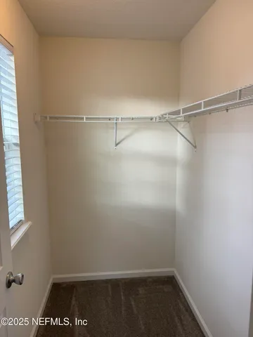 an empty room with wooden floor ceiling fan and windows