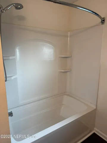 a view of an empty room with a ceiling fan