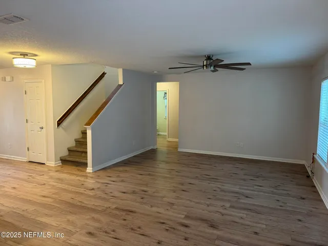 an empty room with wooden floor and mirror