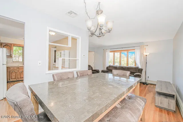 a view of a dining room and livingroom with furniture wooden floor and a chandelier