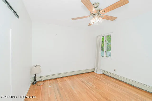 an empty room with a window and a ceiling fan
