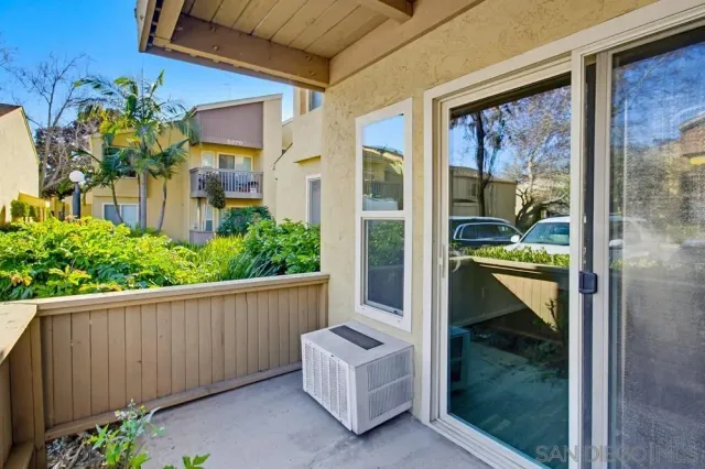 a porch with a bench next to a yard