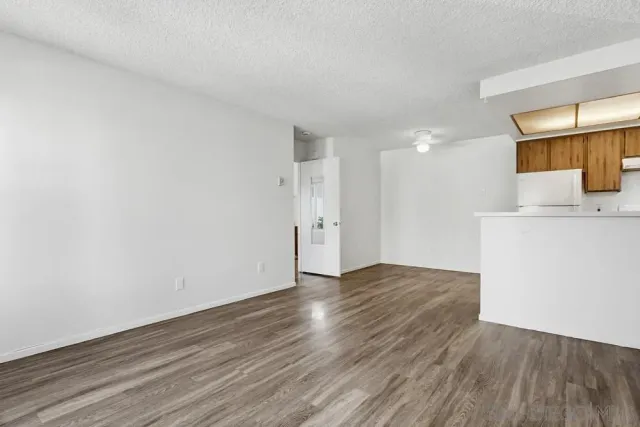 a view of empty room with wooden floor and sink