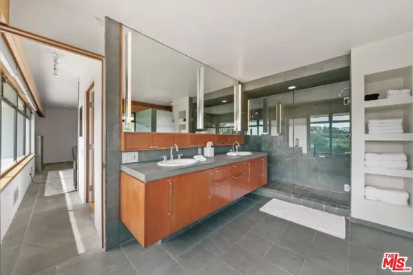 a bathroom with double vanity sinks and a mirror