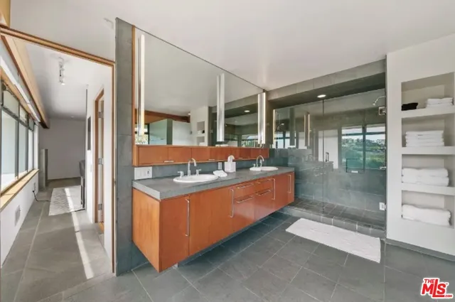 a bathroom with double vanity sinks and a mirror