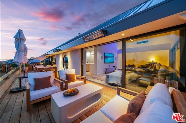 a kitchen with stainless steel appliances a white table chairs and a stove