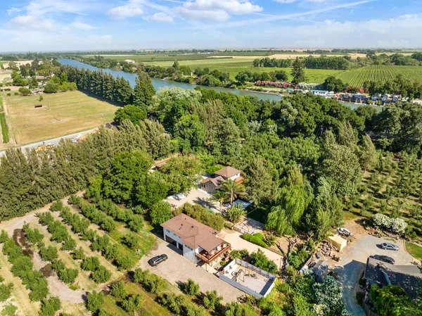 an aerial view of residential houses with outdoor space and trees
