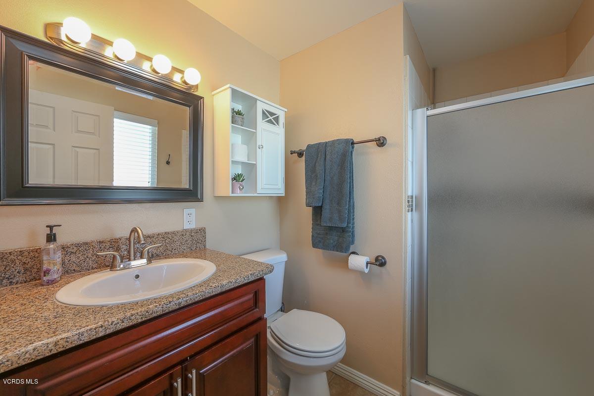 2180 Rhoda Street Simi Valley, CA 93065 - Photo 22 of 30 a bathroom with a granite countertop sink toilet and a mirror