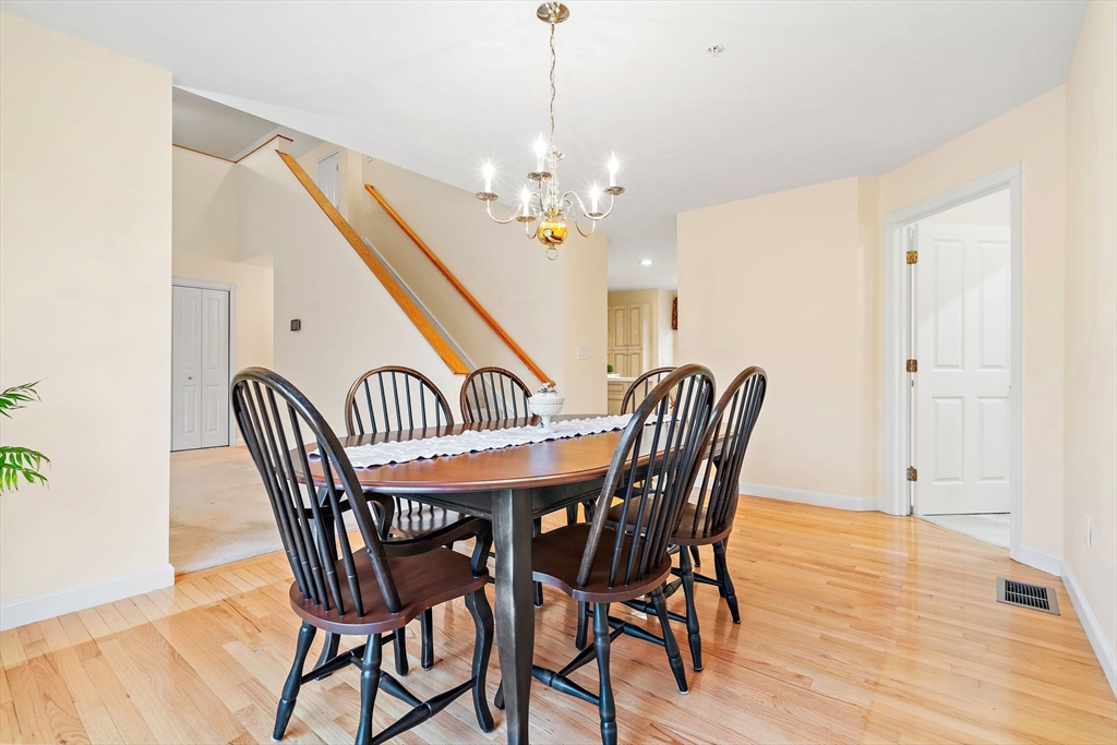7 E Strawberry Lane, Unit E Hudson, MA 01749 - Photo 13 of 38 a view of a dining room with furniture wooden floor and chandelier