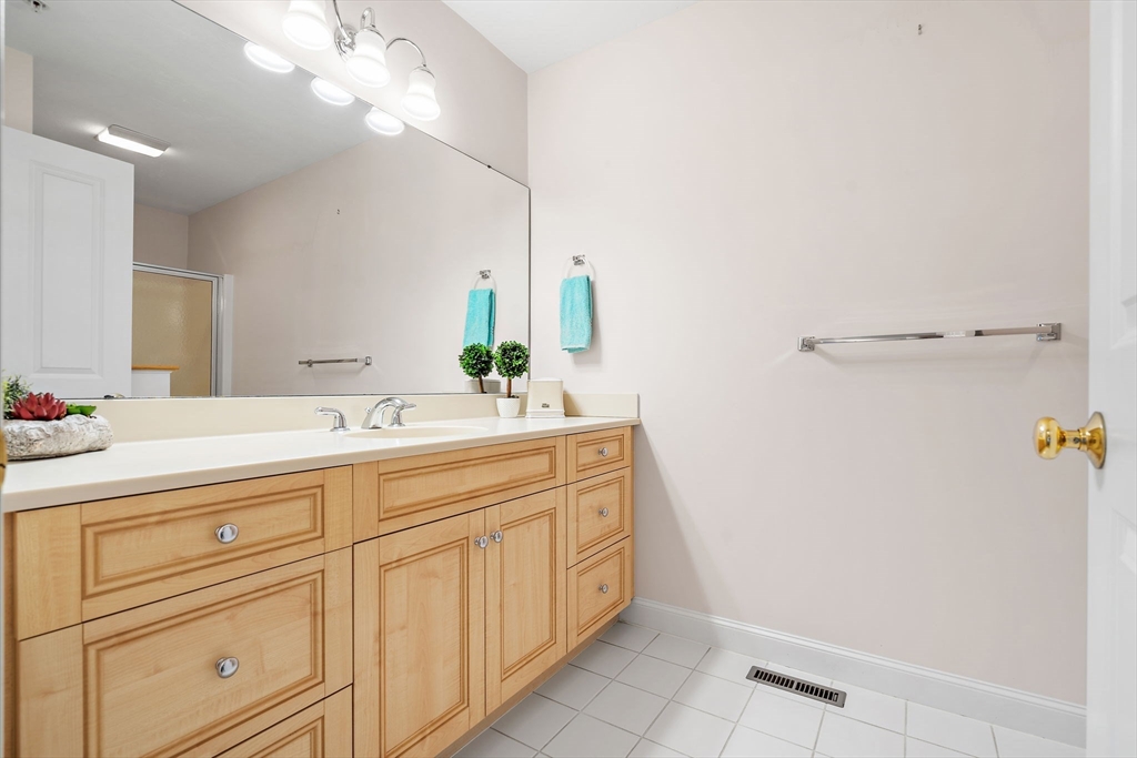 7 E Strawberry Lane, Unit E Hudson, MA 01749 - Photo 24 of 38 a bathroom with a sink and a mirror