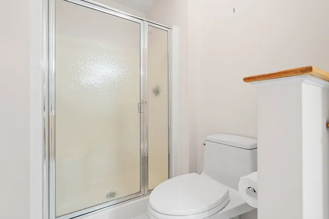 a white toilet sitting next to a shower
