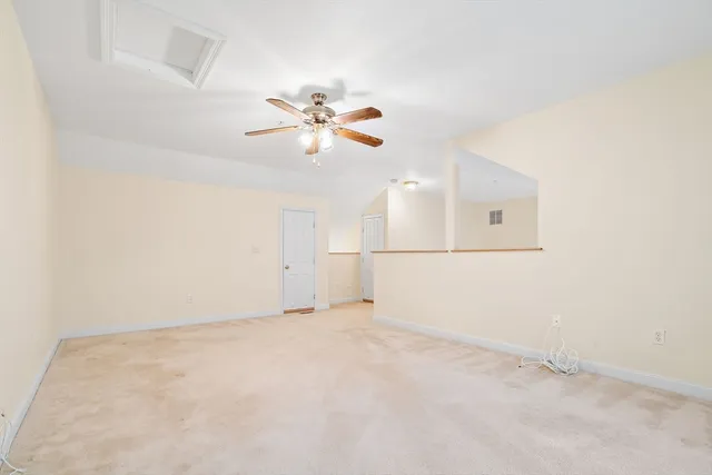 an empty room with chandelier fan and ceiling fan