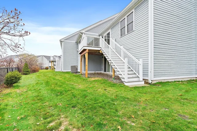 a view of a house with backyard and a tree