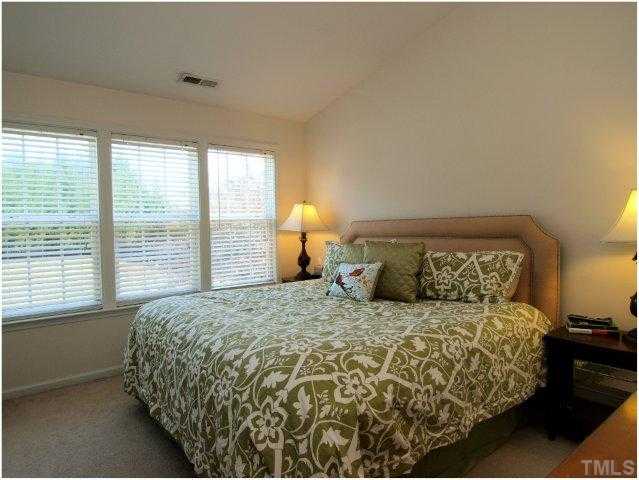 8220 City Loft Court Raleigh, NC 27613 - Photo 12 of 19 a bed sitting in a bedroom next to a window
