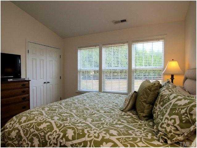 8220 City Loft Court Raleigh, NC 27613 - Photo 13 of 19 a bed sitting in a bedroom next to a window and dresser