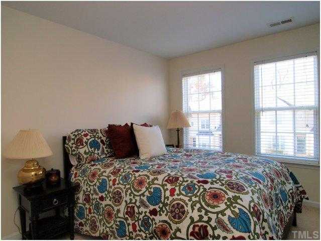 8220 City Loft Court Raleigh, NC 27613 - Photo 16 of 19 a large bed sitting in a bedroom next to a window