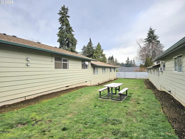 a backyard of a house with table and chairs