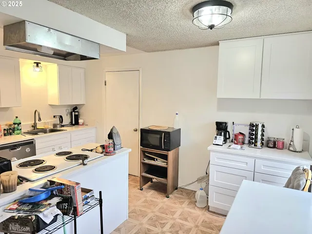 a kitchen with a refrigerator and a stove top oven