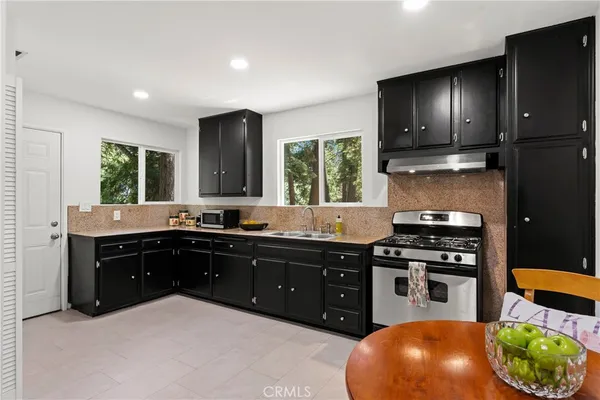a kitchen with stainless steel appliances granite countertop a stove a sink and a microwave