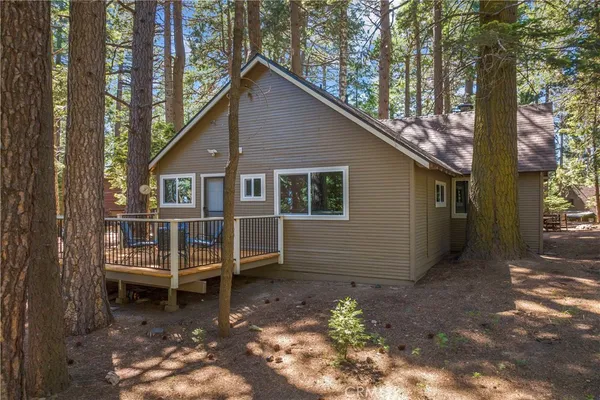 a view of a house with a yard and wooden deck
