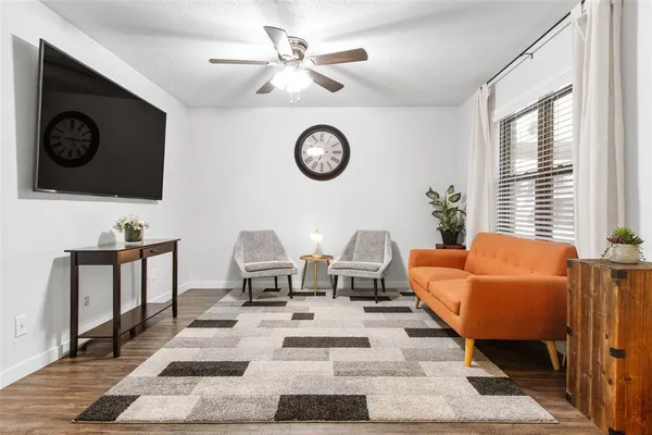 a living room with furniture a rug and a window