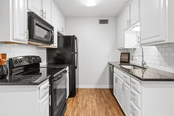 a kitchen with stainless steel appliances granite countertop a refrigerator stove and sink