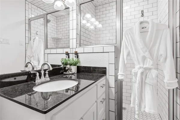 a bathroom with a granite countertop sink and a mirror