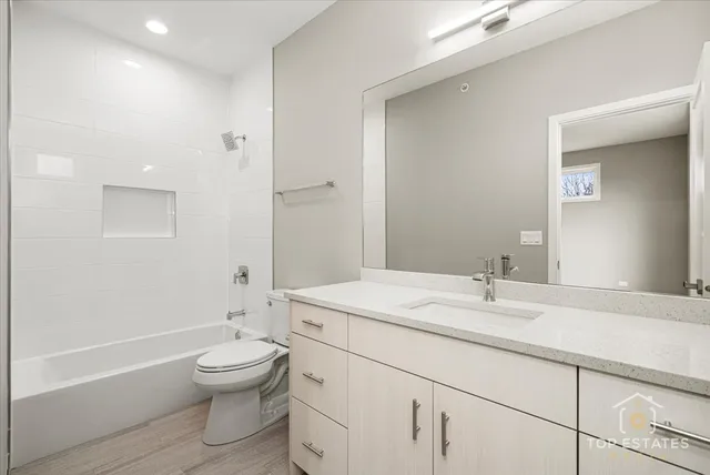 a bathroom with a sink toilet vanity and tub