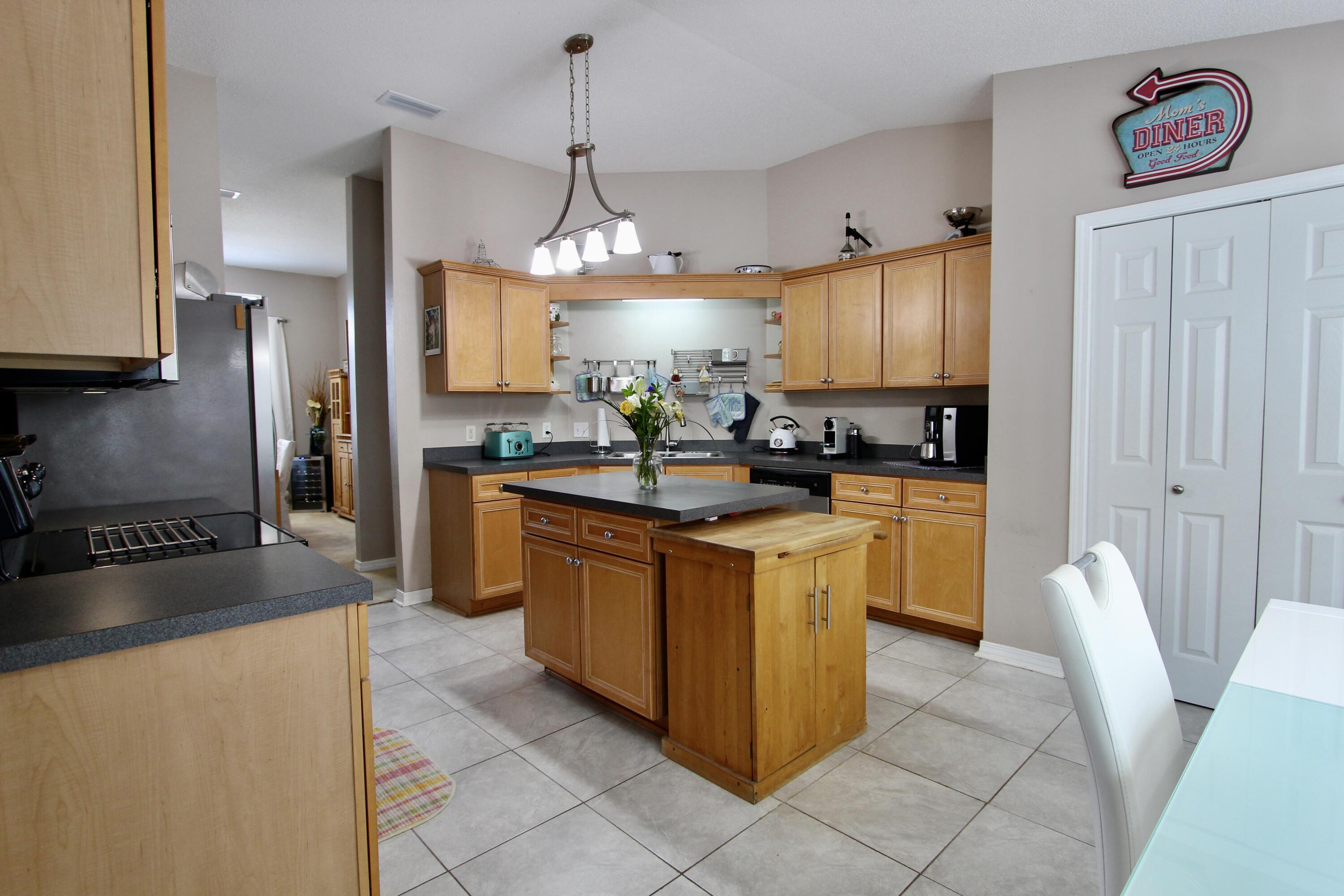 7183 Riverview Road Navarre, FL 32566 - Photo 12 of 39 a kitchen with stainless steel appliances granite countertop a sink counter space cabinets and a refrigerator