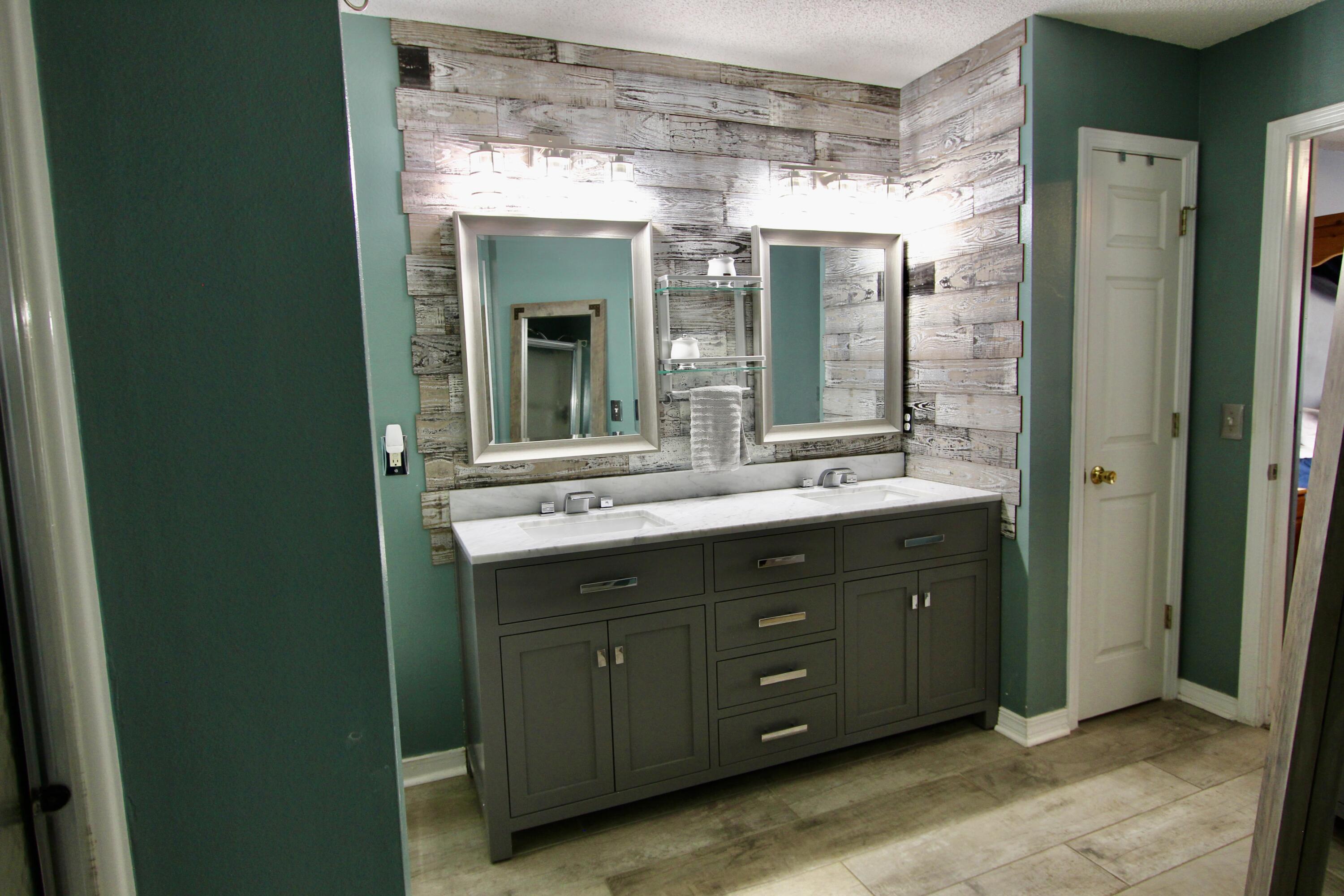 7183 Riverview Road Navarre, FL 32566 - Photo 23 of 39 a bathroom with a double vanity sink mirror and shower