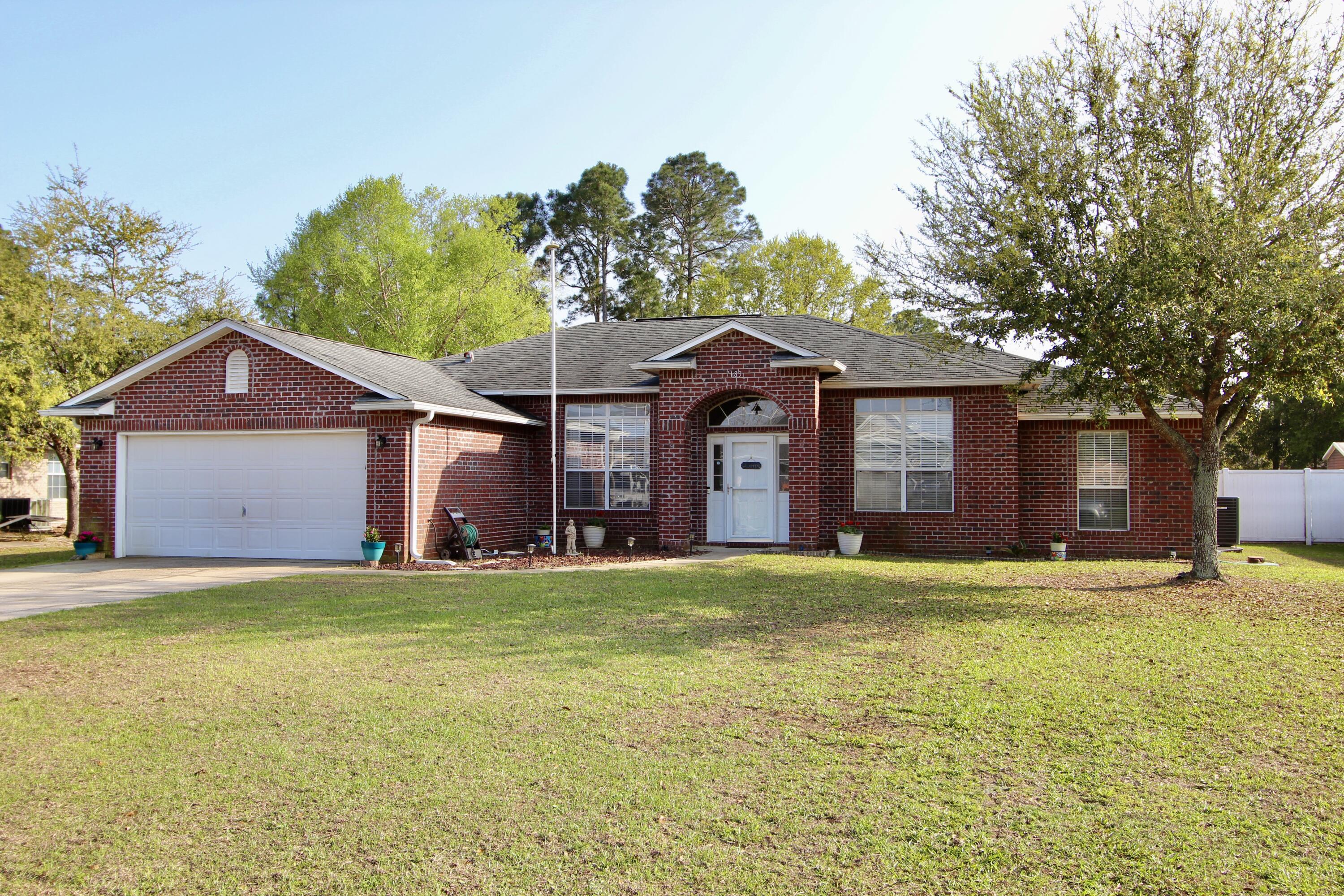 7183 Riverview Road Navarre, FL 32566 - Photo 3 of 39 a large house with a big yard and large trees