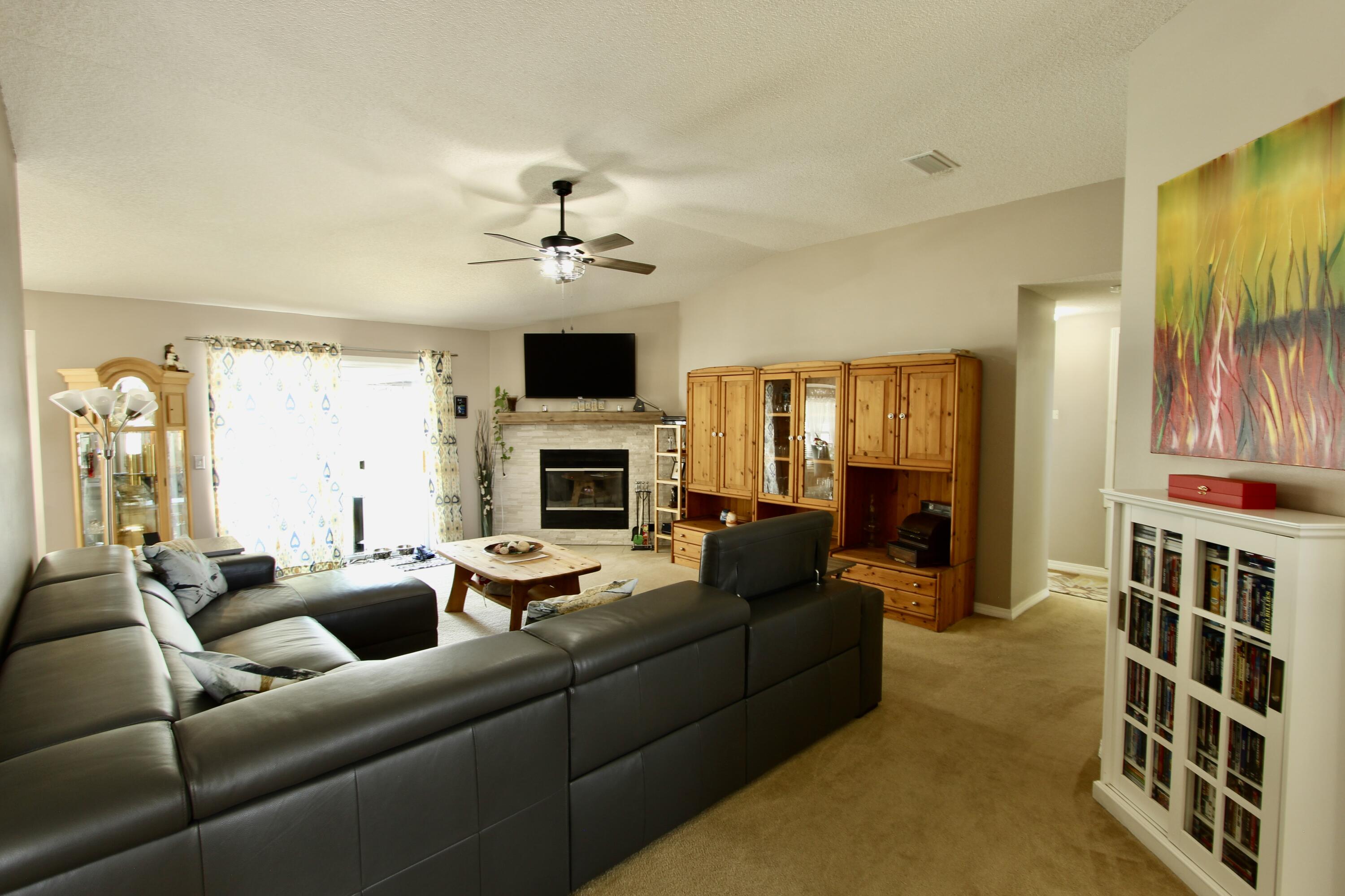 7183 Riverview Road Navarre, FL 32566 - Photo 5 of 39 a living room with furniture fireplace and a flat screen tv