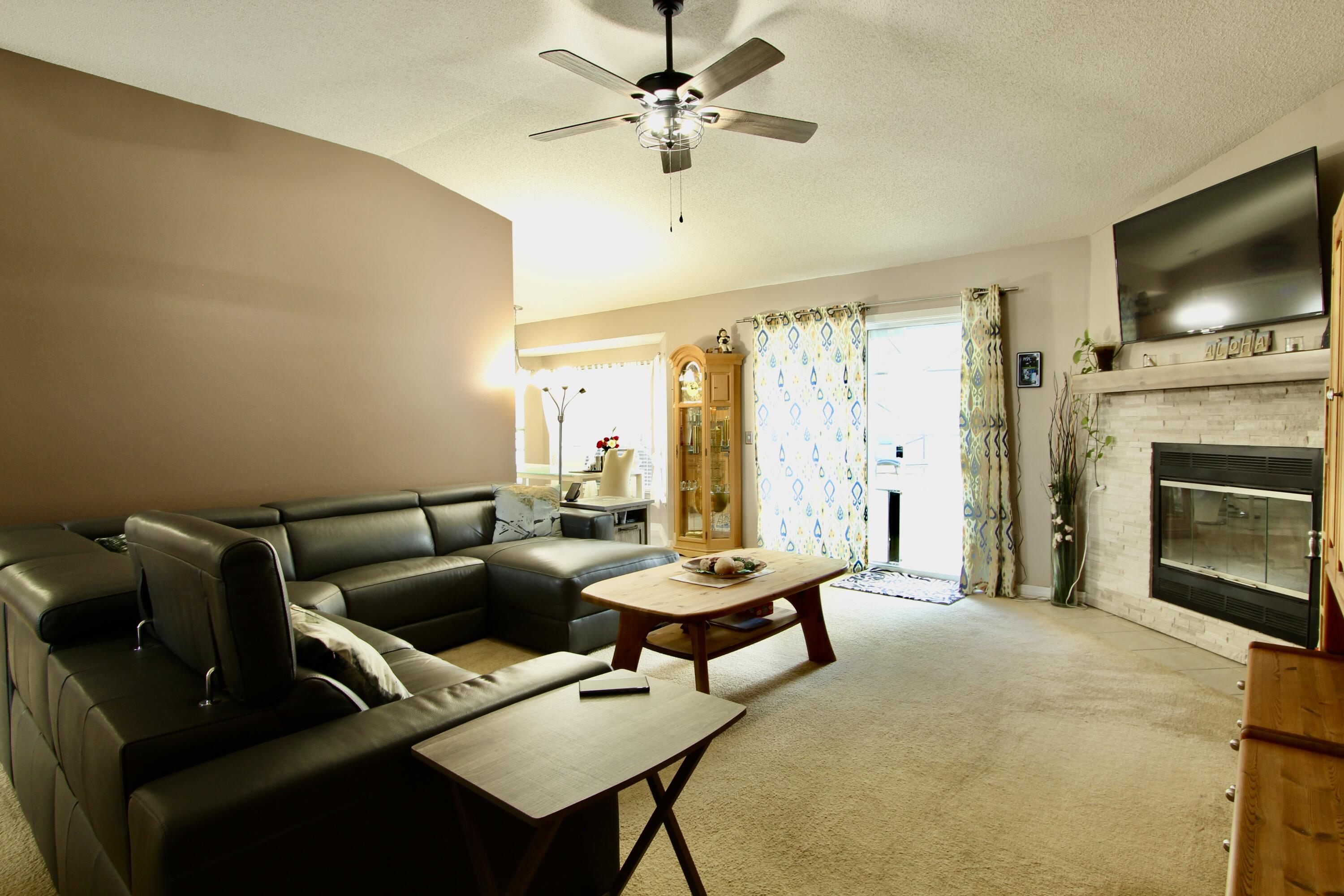 7183 Riverview Road Navarre, FL 32566 - Photo 6 of 39 a living room with furniture a flat screen tv and a fireplace