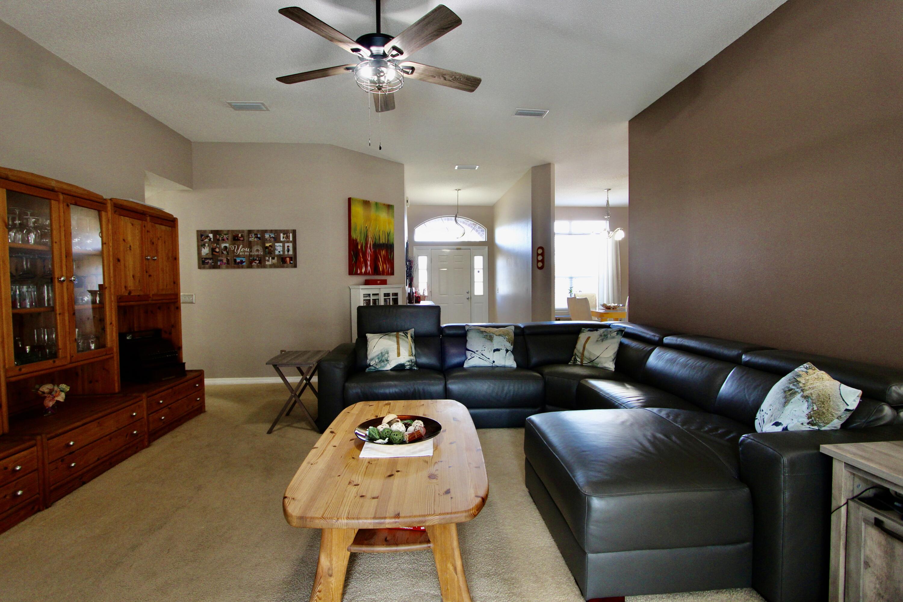 7183 Riverview Road Navarre, FL 32566 - Photo 8 of 39 a living room with furniture a rug and a chandelier